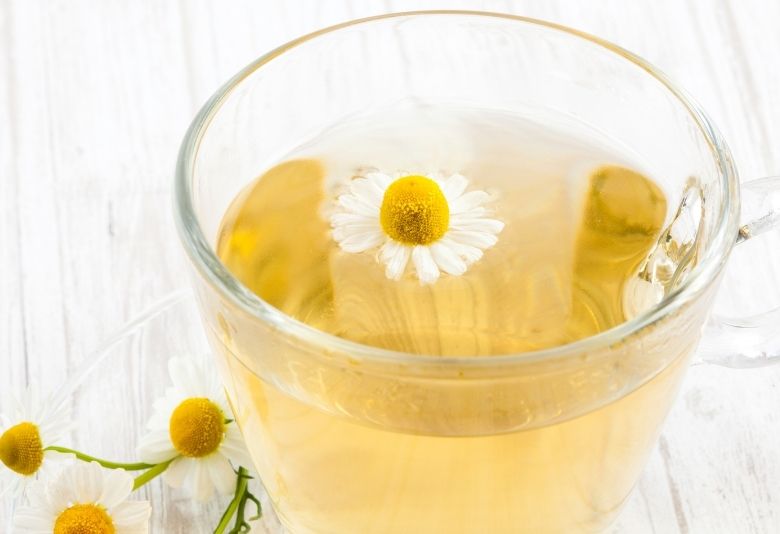 Une tasse d'infusion à la camomille, idéale pour apaiser la digestion et soutenir la perte de poids grâce à ses propriétés relaxantes et digestives.