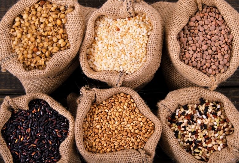 Des sacs de céréales variées, illustrant l'importance des aliments pour améliorer la digestion et favoriser la perte de poids.