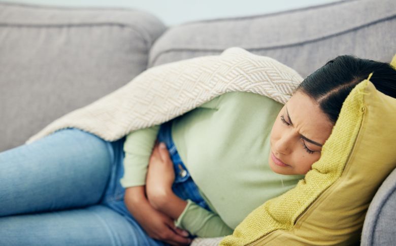 Femme souffrant de douleurs abdominales, un signe que certains repas du soir peuvent perturber la digestion et freiner la perte de poids.