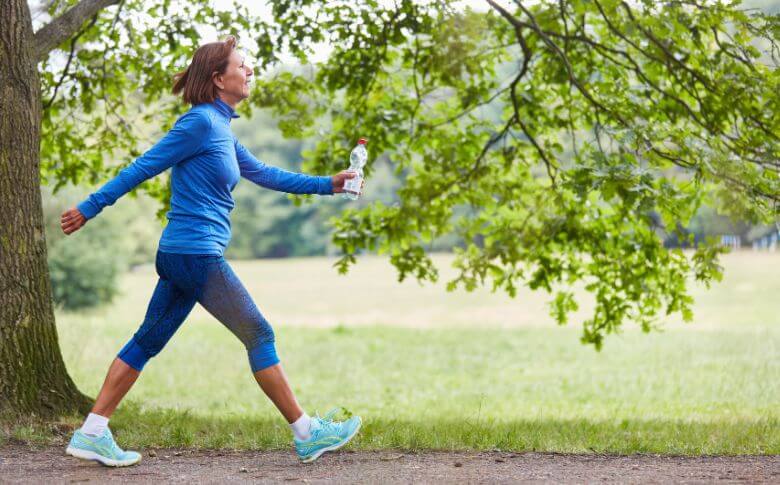 Femme marchant dans la nature, une activité simple et efficace pour soutenir une perte de 15 kg tout en améliorant le bien-être général.