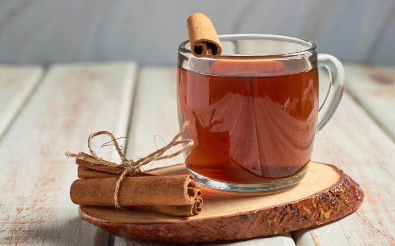 Tasse chaude de cannelle, une boisson réconfortante qui favorise la digestion et soutient la perte de poids de manière naturelle.